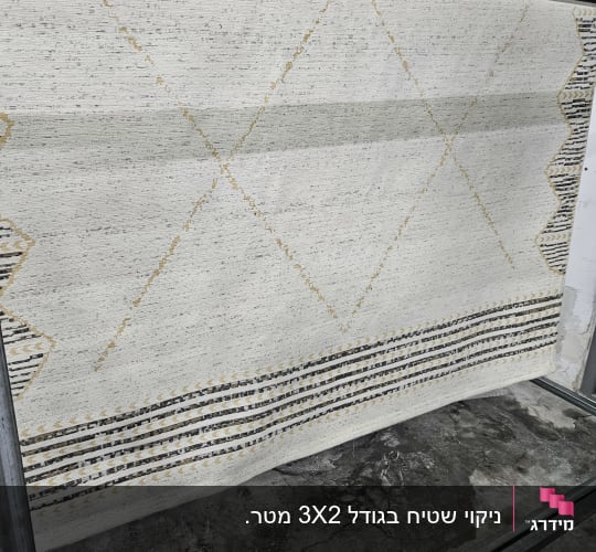 שטיח תלוי על מתקן מתכת לניקוי